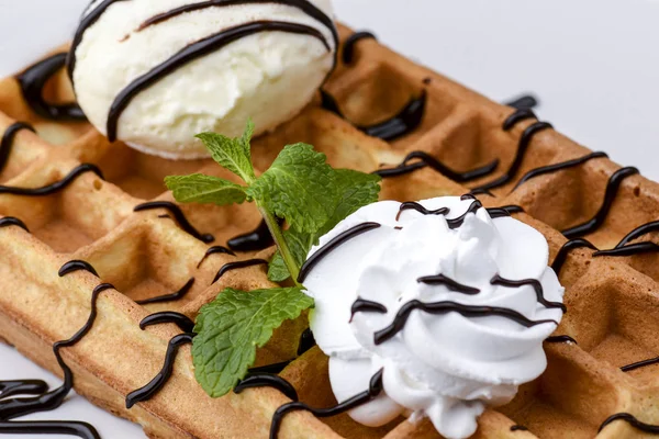 Plate of belgian waffles dessert with ice cream and chocolate caramel sauce on wooden table background. — 스톡 사진