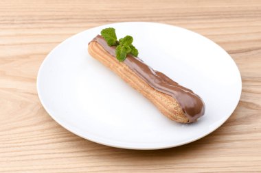 Geleneksel Fransız tatlısı. Nane yaprağıyla beyaz tabakta kremalı ve çikolatalı nefis ekler..