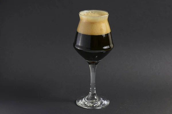 One tall glass of cold dark craft beer over black background. Copy space. — Stock Photo, Image