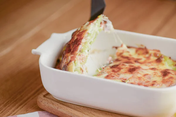 Κλασικά λαζάνια με μπολονέζικη σάλτσα, με τυρί στρωμένο ανάμεσα σε φύλλα σερβιρισμένα σε λευκό πιάτο σε ξύλινο φόντο — Φωτογραφία Αρχείου