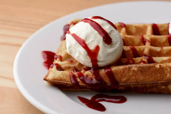 Plate of belgian waffles with ice cream and fruit strawberry caramel sauce on wooden table background — 스톡 사진