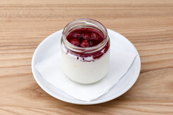 Želé s bobulemi ve sklenici. Italský dezert panna cotta na lehkém dřevěném stole. — Stock fotografie