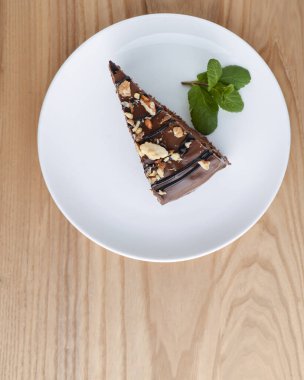 Üstünde krema olan çikolatalı örümcek ağı pastası beyaz bir tabakta servis ediliyor..