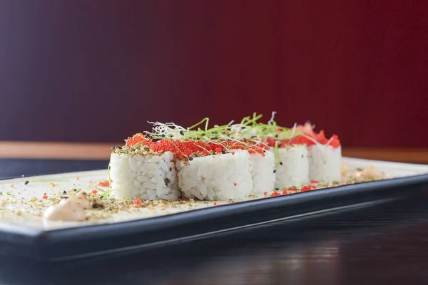 Maki Sushi California rolls with fresh salmon, cucumber and cream cheese philadelphia inside with red caviar and herbs