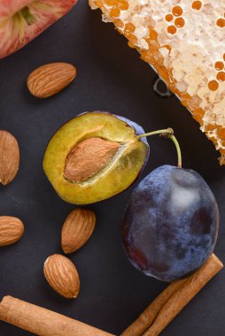 Tarçın, badem, erik, bal ve elma siyah masa arkaplanında, üst görünümü kopyala.