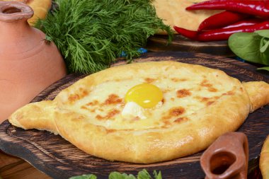Geleneksel Gürcü mutfağı. Geleneksel Ajarian ekmek khachapuri. Peynirli ve yumurtalı açık turta.