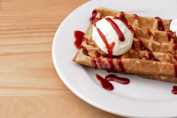 Plate of belgian waffles with ice cream and fruit strawberry caramel sauce on wooden table background — 스톡 사진