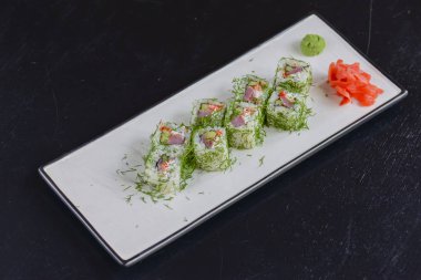 Somon suşisi ruloları zencefil, wasabi ve soya sosuyla servis edilir. Japon mutfağı..