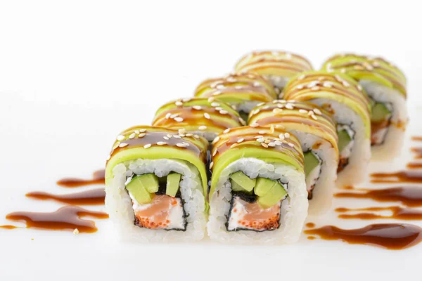 Uramaki tori sushi, un conjunto de rollos verdes con semillas de sésamo y salsa unagi aislada en blanco. Ocho piezas de sushi . — Foto de Stock