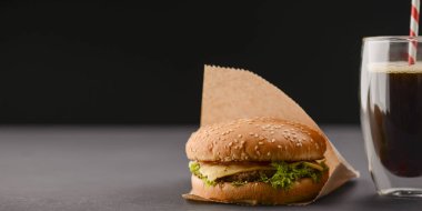 Amerikan aperatifi, büyük hamburger ve bir bardak kola. Fast food, abur cubur kavramı.