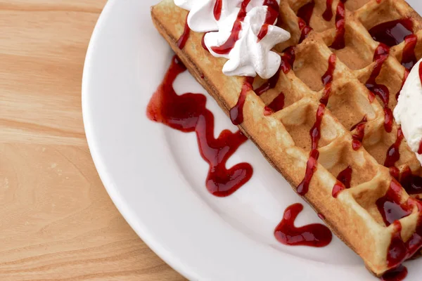Plate of belgian waffles with ice cream and fruit strawberry caramel sauce on wooden table background — Stock Photo, Image
