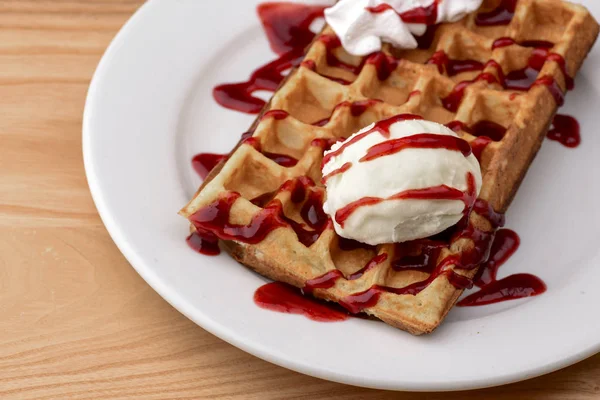 Plate of belgian waffles with ice cream and fruit strawberry caramel sauce on wooden table background — Stock Photo, Image