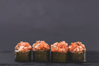 Dört parça baharatlı Maki suşi, yanında da füme yılan balığı, peynir ve havyar..