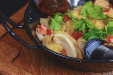 İçinde deniz mahsulleri olan kuskus. Lokantada servis edilen üç istiridye, ahşap kesme tahtasının üzerinde, kırsal karanlık masada..