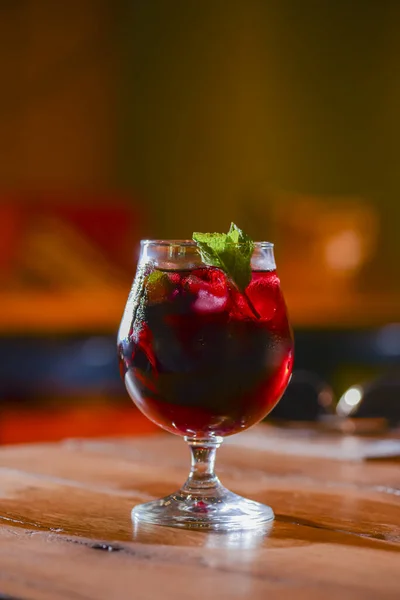 Classic alcoholic summer cocktail with lemon and mint garnish on a bar table.