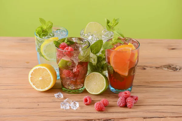 Четыре тропических смешанных напитка, апельсин, лимон и малина коктейли на ярком пастельно-зеленом фоне . — стоковое фото