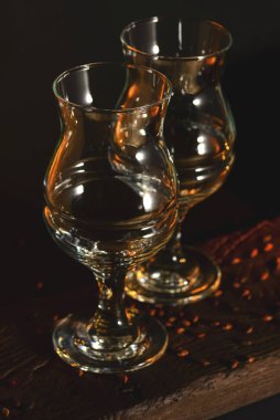 Two empty beer glasses over black background.