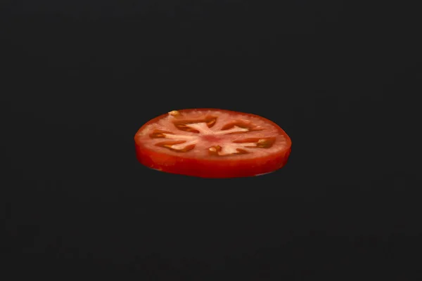 Små biter tomat isolert på svart bakgrunn. Kopier plass. Ingredienser for å lage en hamburger . – stockfoto