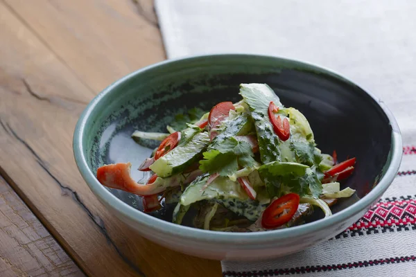 Comida saudável. Cozinha ucraniana. Salada verde fresca com pepinos, pimenta, salsa, endro e carne servida na mesa . — Fotografia de Stock