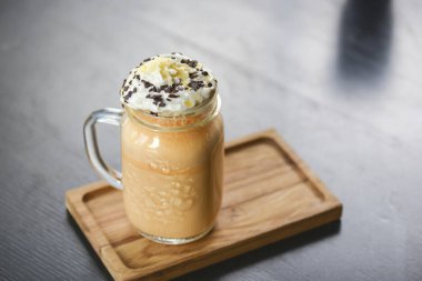 Dondurma, krema ve çikolatalı buzlu kahve. Bir bardak soğuk, şekerli, bulanık arka planı olan kahve..