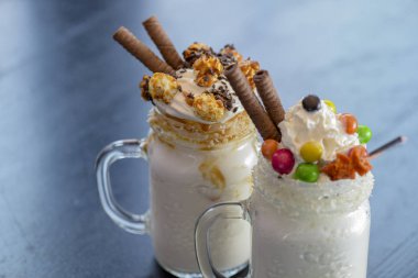 İki bardak ya da kırsal ahşap masada garip titreşimler. Karamelli lokum şekerli milkshake kokteyli.