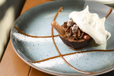 Lokantada bir fincan çayla mavi tabakta servis edilen lezzetli tatlı..