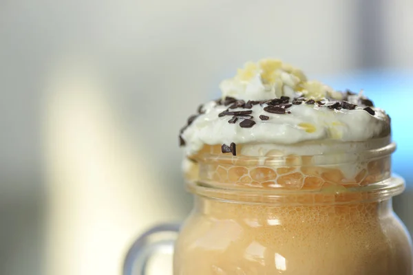 Kopi dingin dengan es dan krim dan coklat di atasnya. Segelas kopi manis dingin dengan latar belakang kabur . — Stok Foto