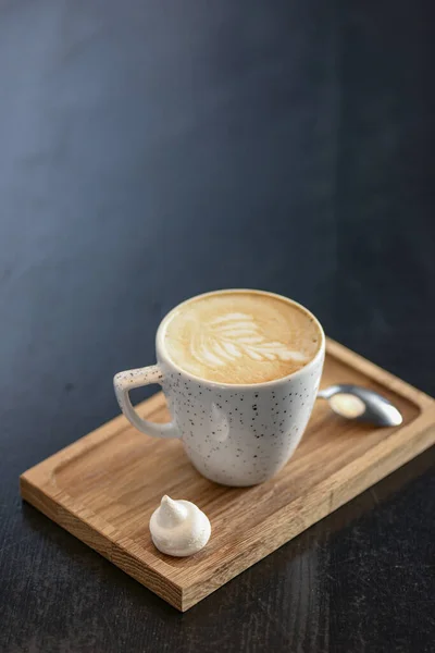 Filiżanka kawy na małej desce na czarnym tle. Sztuka latte. Mały kubek do kawy i łyżka. — Zdjęcie stockowe