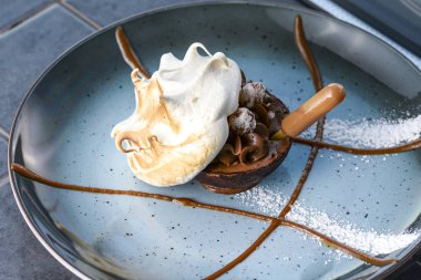 Lokantada bir fincan çayla mavi tabakta servis edilen lezzetli tatlı..