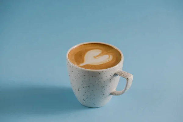 Latte art a tetején forró kávé csésze felett pasztell kék háttér. Szív latte művészet. Űrtranszparens másolása. — Stock Fotó