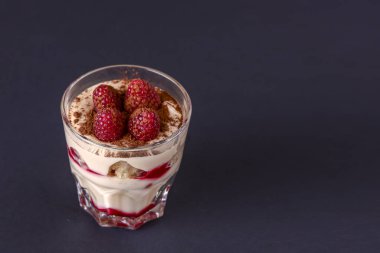 İtalyan tatlı panna cotta ile ahududu ve kakao tozu küçük bardakta servis edilir..