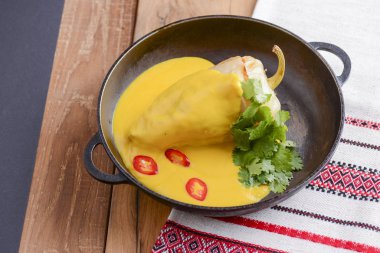 Kırmızı biber ve kıyma ve kabak sosu kırsal ahşap bir masada servis edilir..