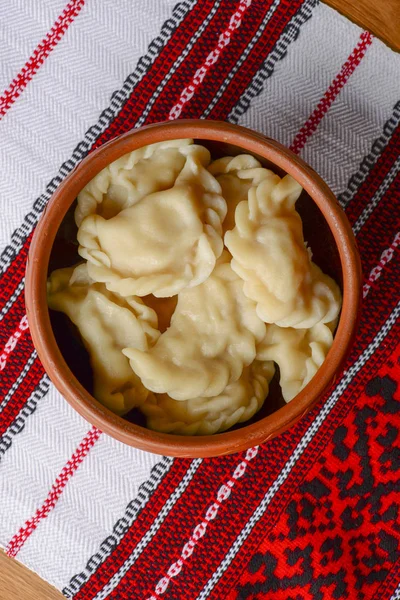 Gnocchi di carne ucraini tradizionali. Pelmeni bolliti serviti in ciotola con salsa sulla tovaglia tradizionale ucraina — Foto Stock