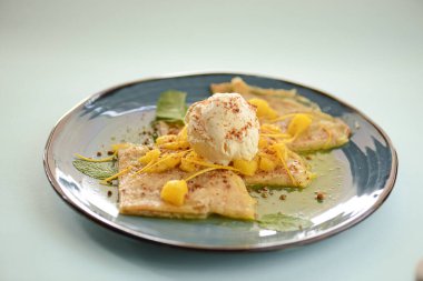 Ananas meyveli ve çiğ nane yapraklı vanilyalı dondurma tatlısı. Tatlı, lezzetli, soğuk tatlı mavi tabakta.