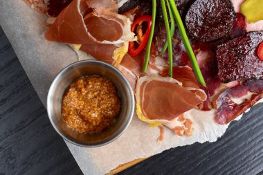 Koyu kırsal ahşap masa üzerinde yeşil sebzeli et carpaccio..