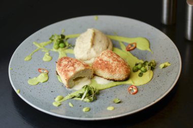 Cordon bleu tavuk pirzolası. Keiv pirzola ve sos koyu kırsal ahşap masada mavi bir tabakta servis edilir..