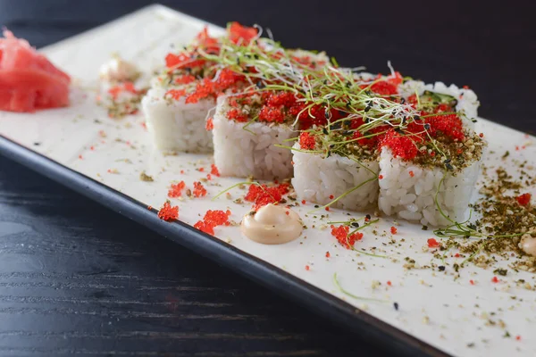 Maki Sushi California rolls with fresh salmon, cucumber and cream cheese philadelphia inside with red caviar and herbs