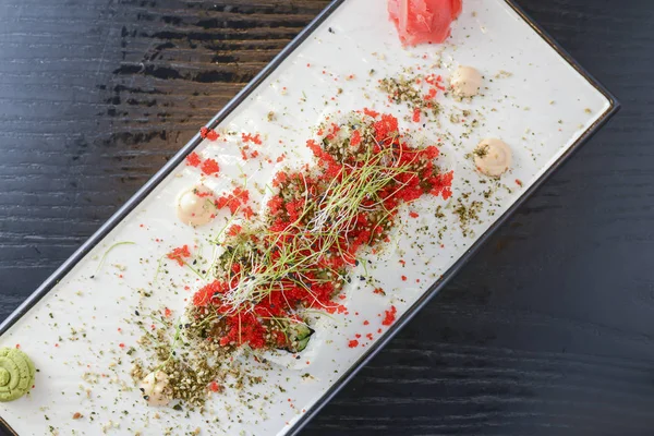 Maki Suşi California ruloları taze somon, salatalık ve krem peynirli Philadelphia kırmızı havyar ve bitkilerle birlikte.