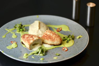 Cordon bleu tavuk pirzolası. Keiv pirzola ve sos koyu kırsal ahşap masada mavi bir tabakta servis edilir..