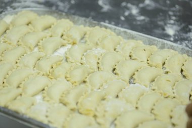 Metal tepside unlu pişmemiş Rus varenisi. Vareniki üretme süreci.