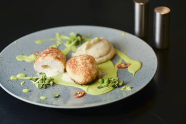 Cordon bleu tavuk pirzolası. Keiv pirzola ve sos koyu kırsal ahşap masada mavi bir tabakta servis edilir..