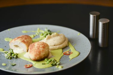 Cordon bleu tavuk pirzolası. Keiv pirzola ve sos koyu kırsal ahşap masada mavi bir tabakta servis edilir..