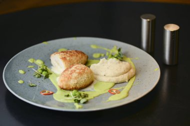 Cordon bleu tavuk pirzolası. Keiv pirzola ve sos koyu kırsal ahşap masada mavi bir tabakta servis edilir..