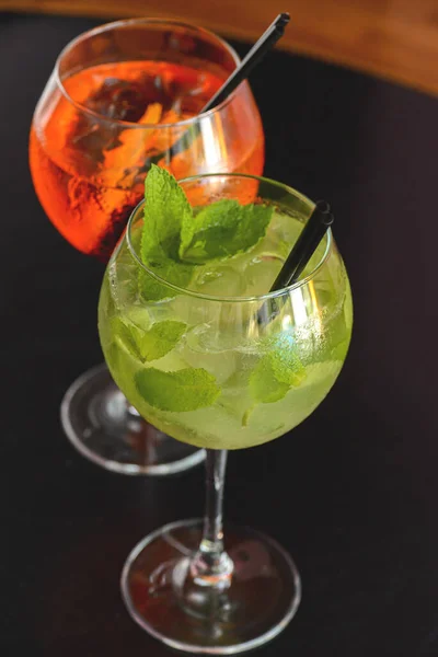 Two mojito alcohol cocktails with plastic straw, tropical beverage with ice, mint and lime, copy space. — Stockfoto