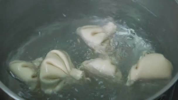 Georgian cuisine. Khinkali or dumplings are boiling in boiled water on the stove in a saucepan. Cooking process. — 图库视频影像