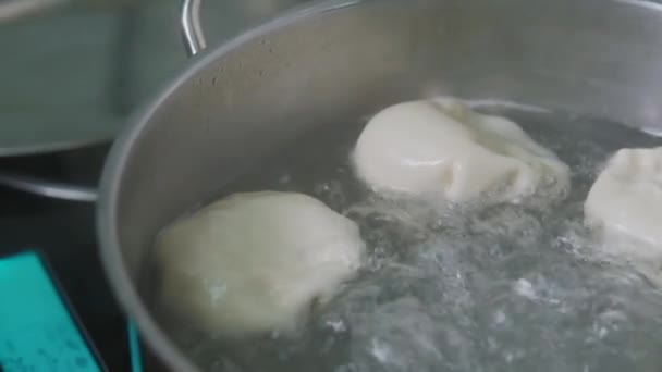 Georgian cuisine. Khinkali or dumplings are boiling in boiled water on the stove in a saucepan. Cooking process. — 비디오