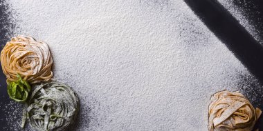 Siyah zemin üzerinde İtalyan spagettisi ve zeytinyağı şişesi ve merdane iğnesi..