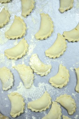 Metal tepside unlu pişmemiş Rus varenisi. Vareniki üretme süreci.