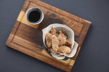 Kızarmış karidesler küçük bir kasede servis ediliyor. Köy ahşap tahtasında soya sosu ile servis ediliyor..