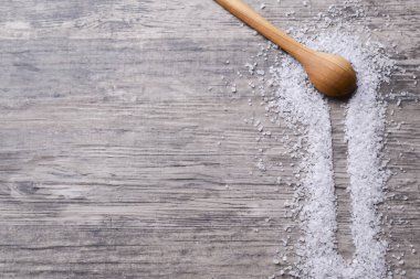 Tahta kaşık hafif bir ahşap masada tuz var. Metin için kopyalama alanı olan web tasarımı pankartı